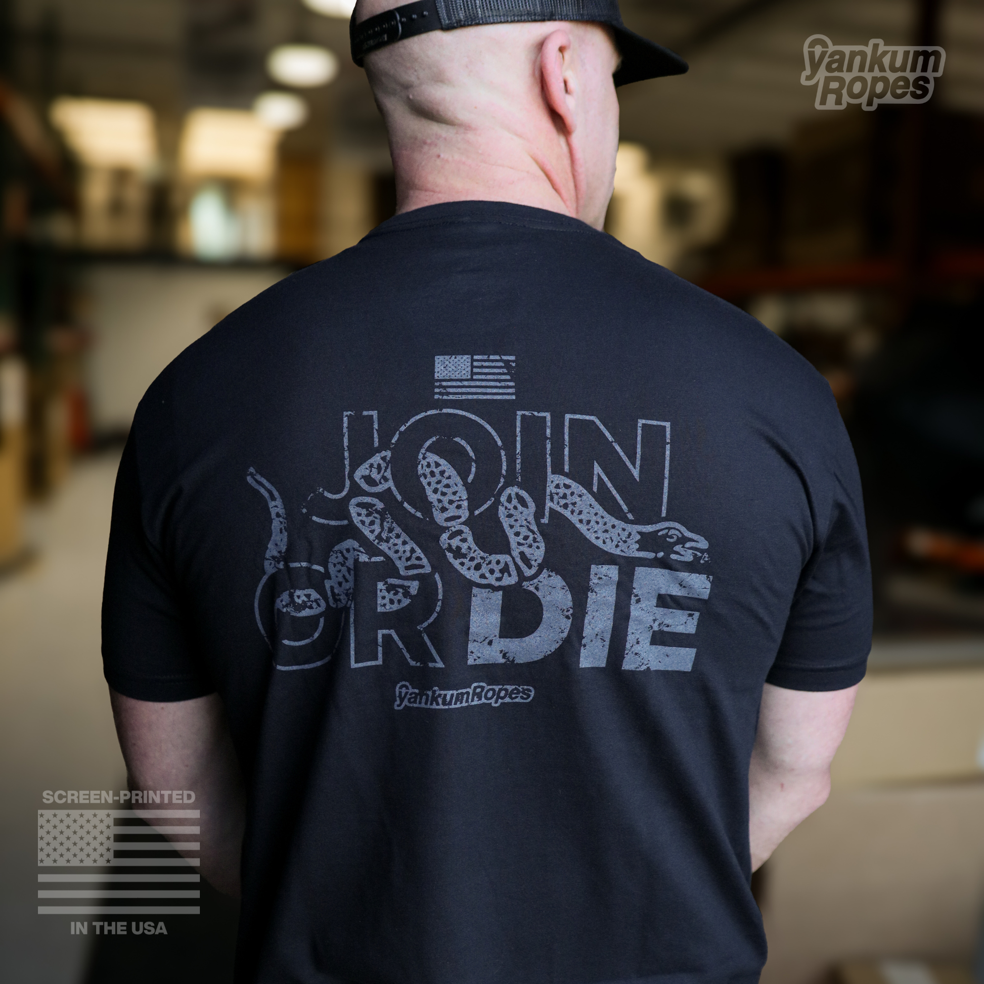 view of the back of the black Yankum Join or Die Tee